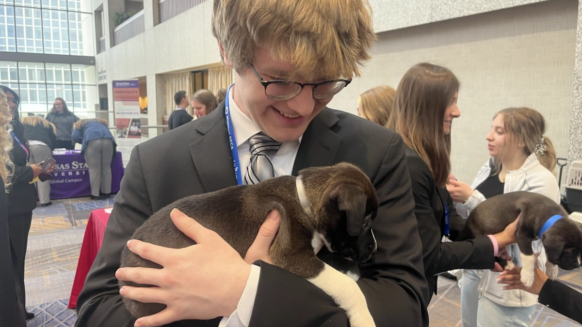 Ryan White (pictured above) is shown holding a puppy at one of the station fundraiser events at DECA SCDC 2023.