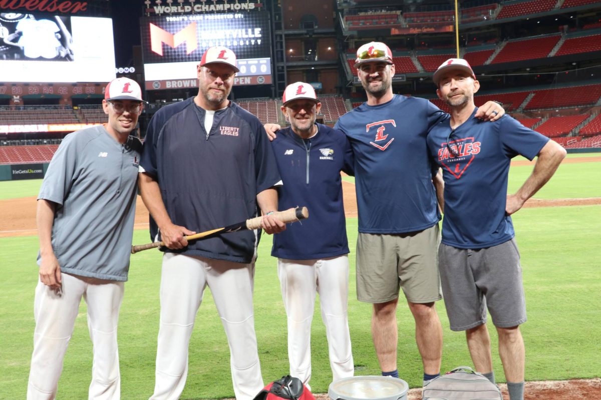 Coaches Karl Ladage, Dan Wheeler, Mark Reeder, Dan Fox and Brian Kinery lock arms at the end of the game. 