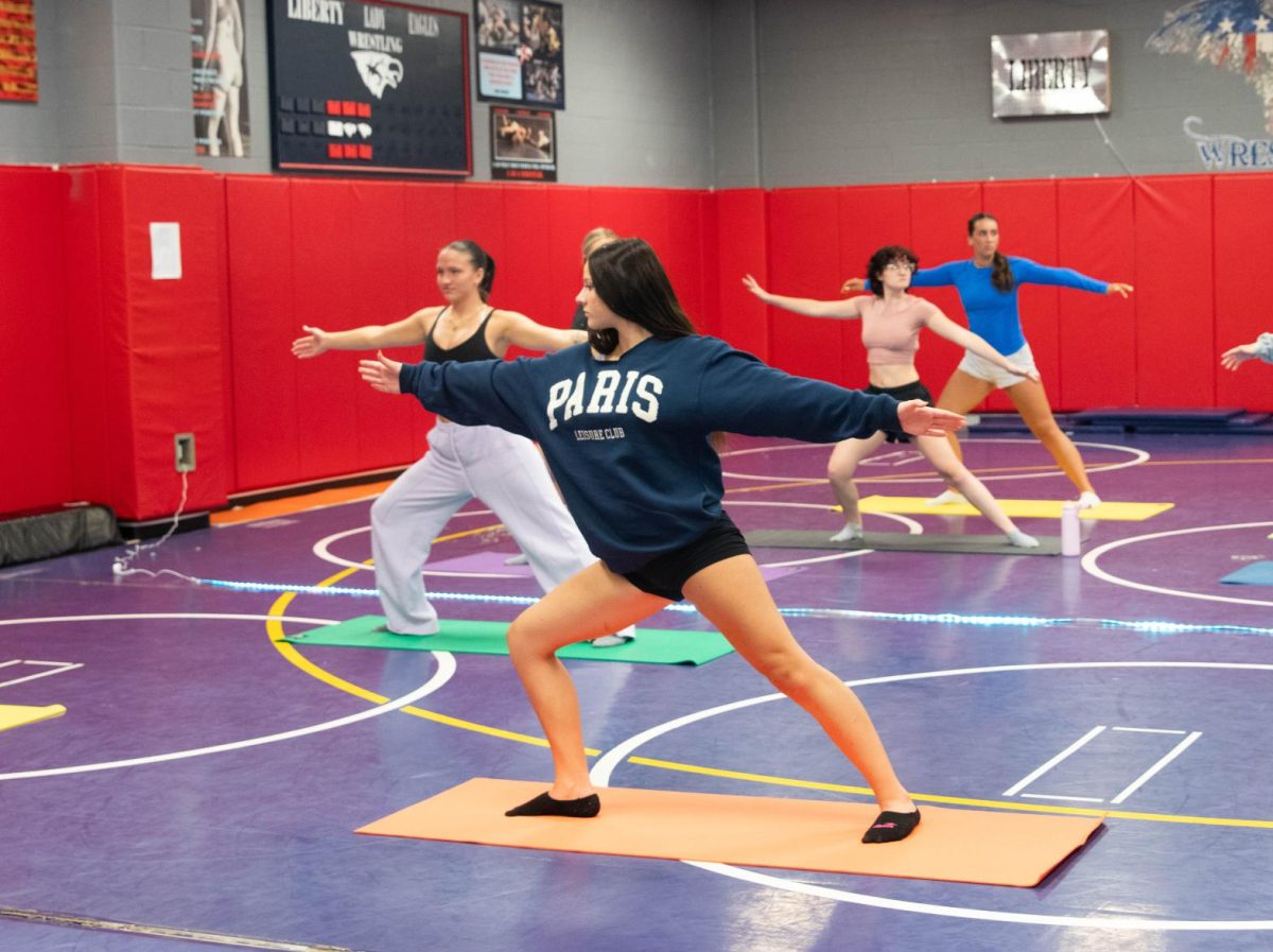 Sophomore Charley Whelan does a warrior pose with her 8th hour yoga class.