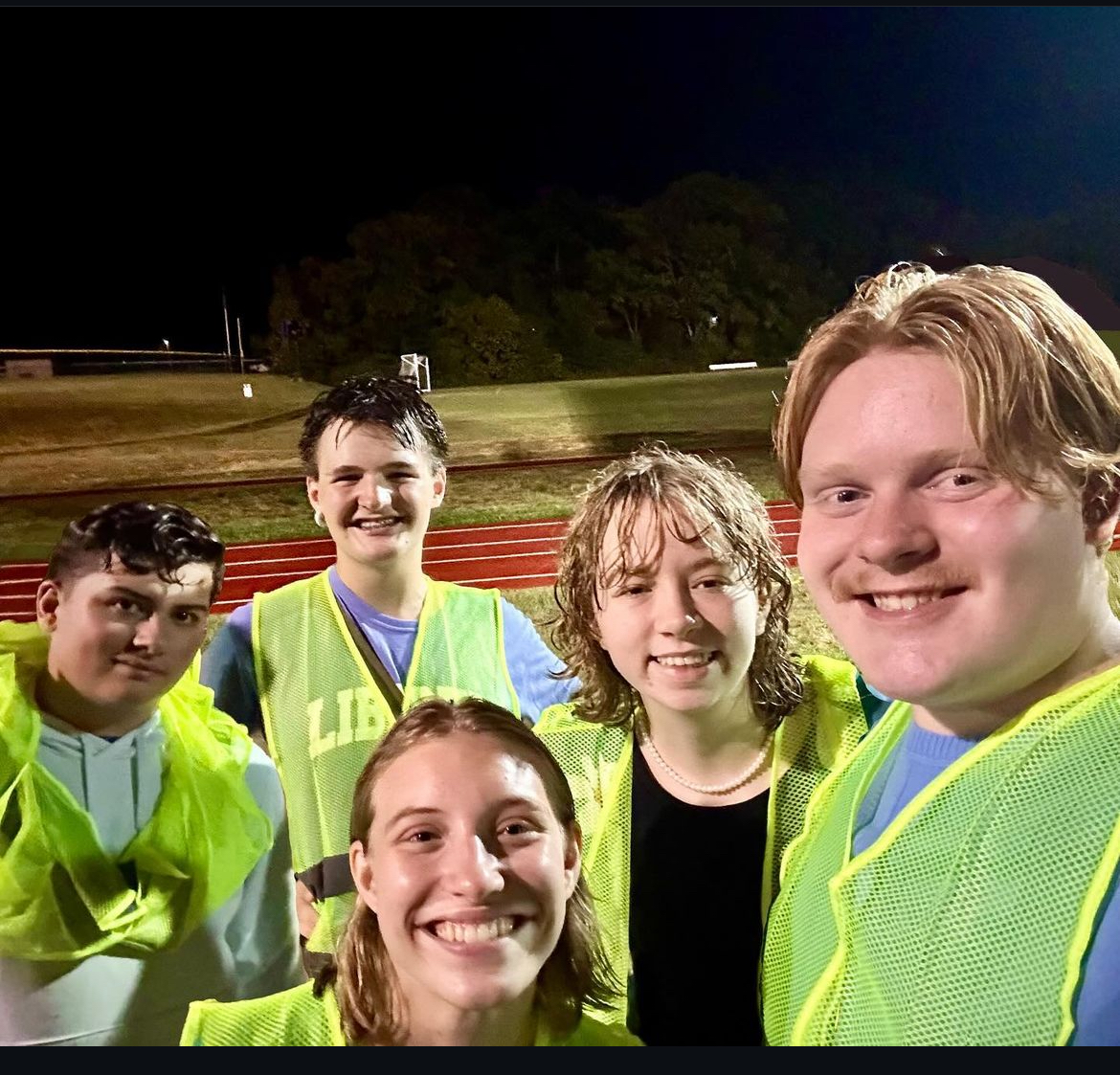 Earth Club students Mark Berry (11), Louis Stoyanov (11), Leah Dudley (11), Clara Walker (12) and Logan Hinds (12) work to clean during a football game. 