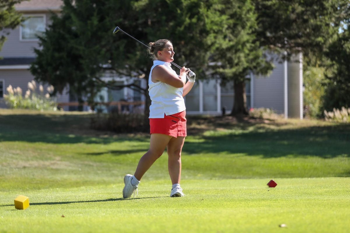 Audrey Keller (12) looks out to the green watching her ball land at the golf match against Troy Buchanan on Payton Lindsay (9) lines up her club to the ball on the rough during the golf match against Troy Buchanan on Sept. 5.