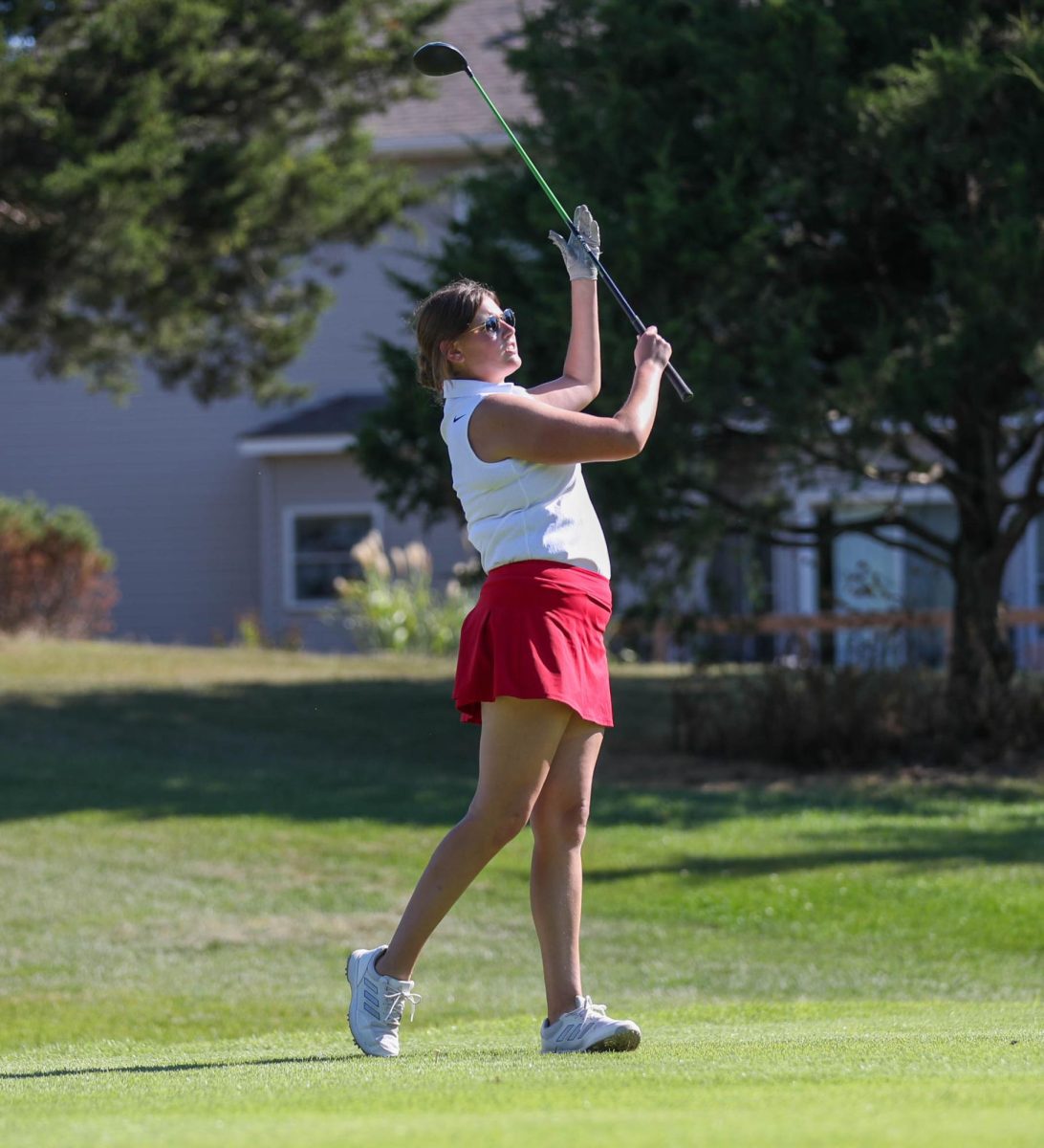 Sophie Heygi (12) swings her club after hitting the ball to the green at the golf match against Troy Buchanan on Payton Lindsay (9) lines up her club to the ball on the rough during the golf match against Troy Buchanan on Sept. 5.