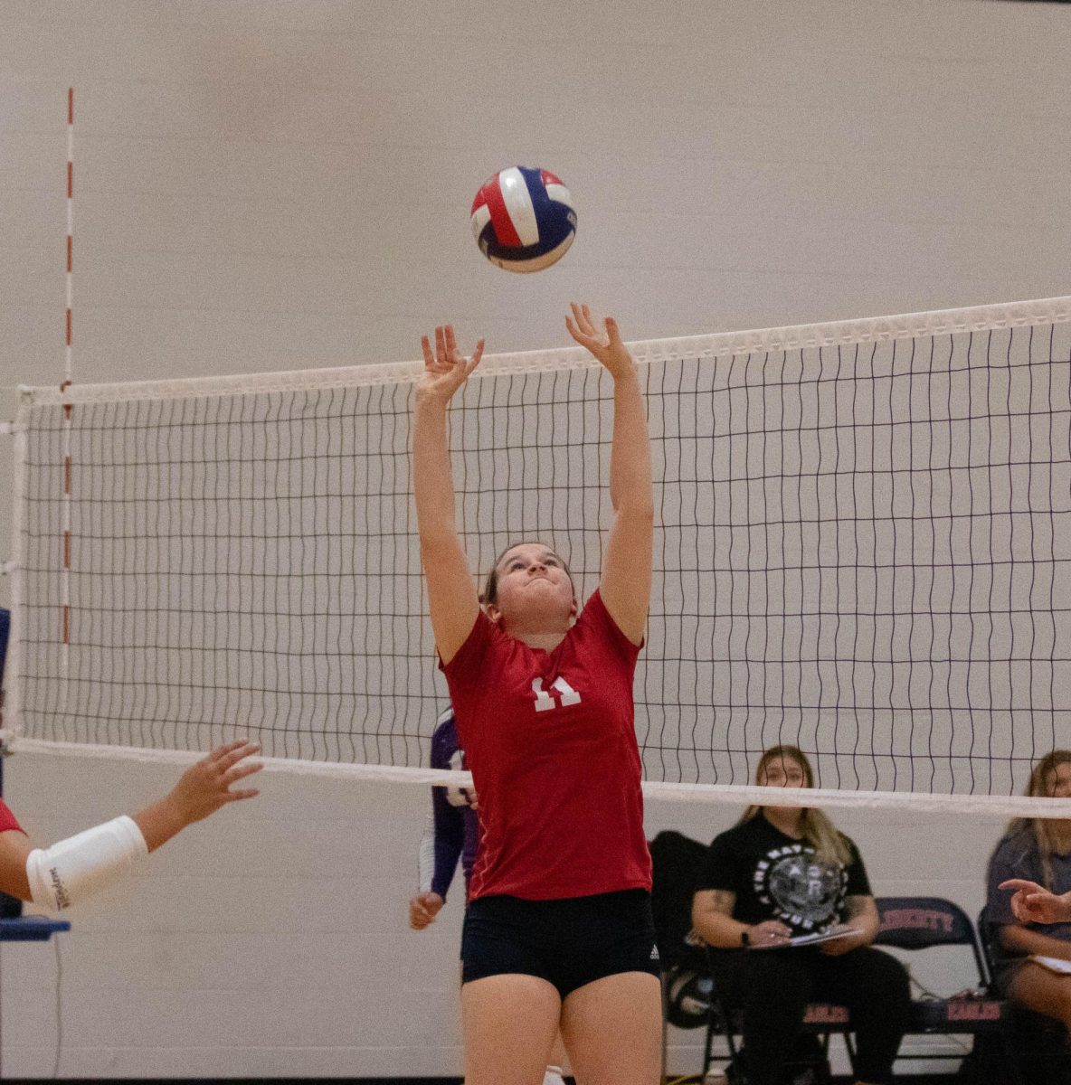 Setter Reagan Grover (9) sets the ball high for her hitter.