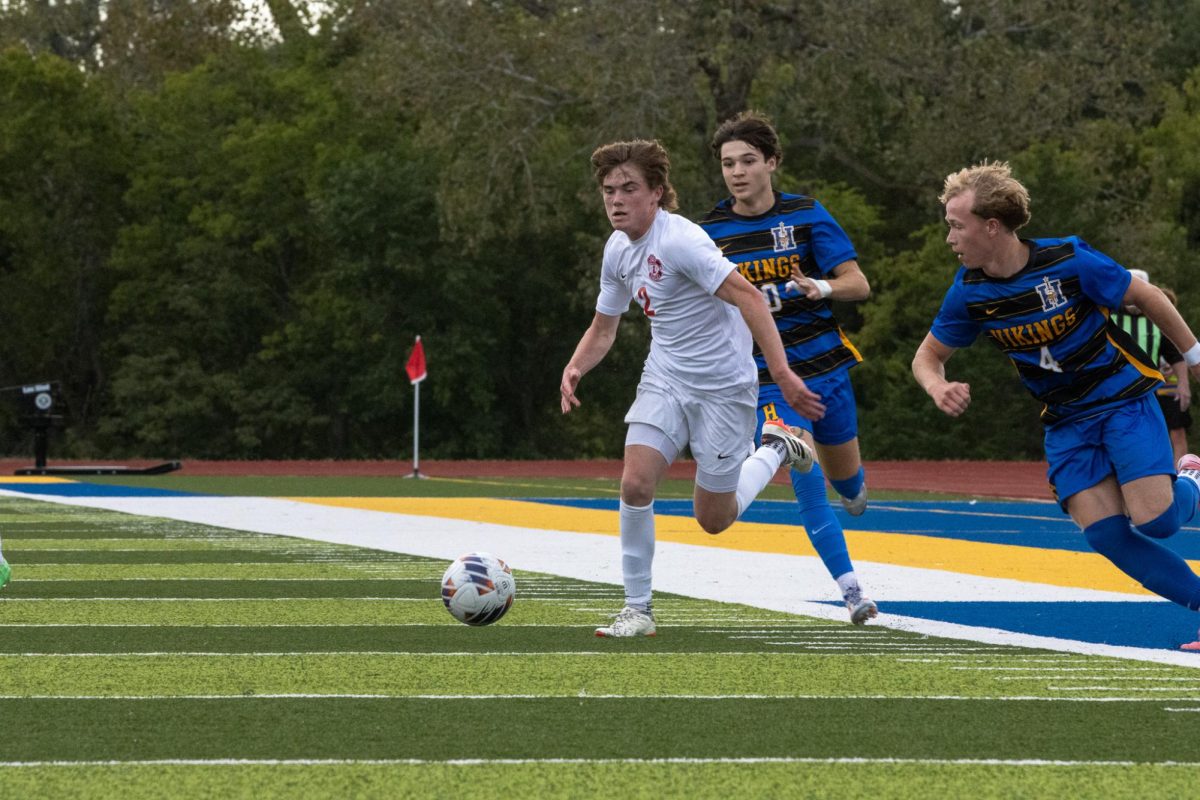 Cannon Nord (11) chases the ball downfield while battling the defenders.