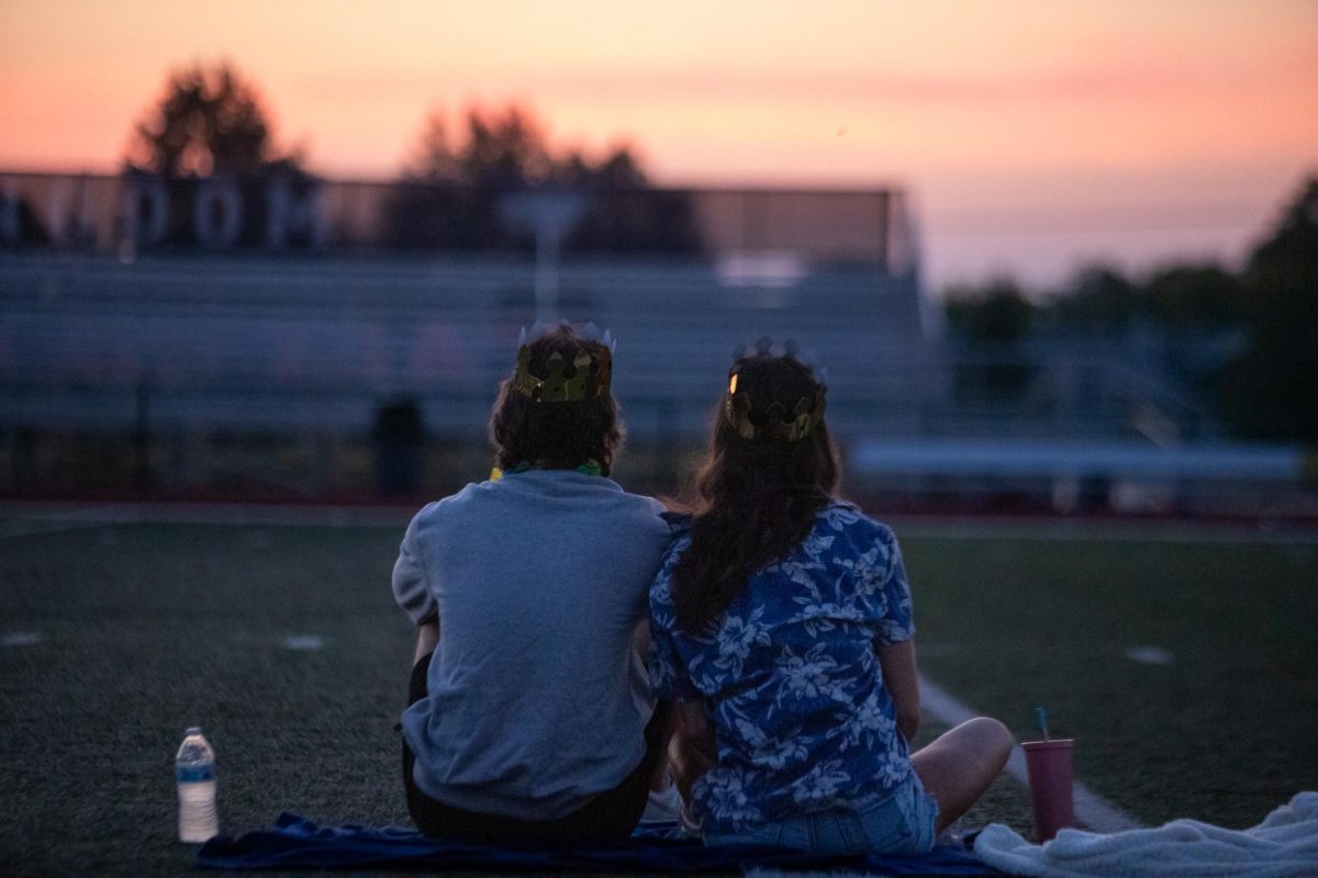 Matthew Mauck and Annabelle Hargrove  watch over the bleachers as the sun rises.