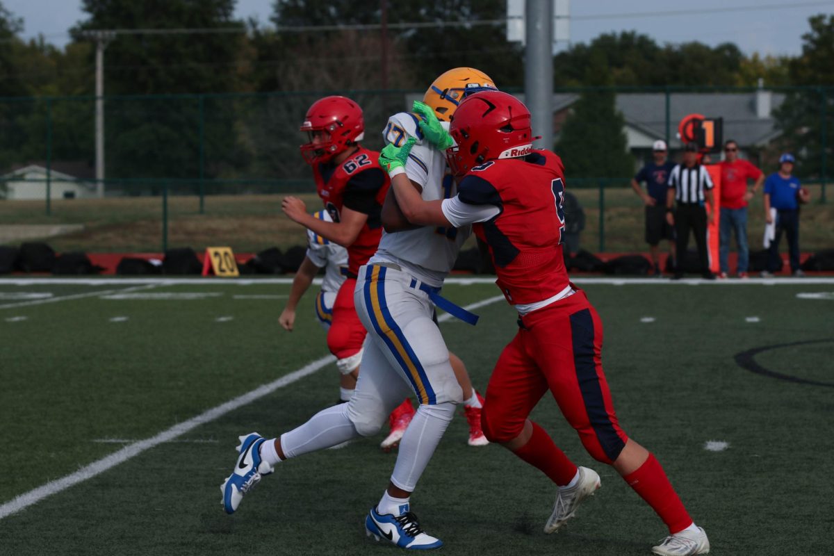 Owen Pierre (9) tackles a Francis Howell player and Evan Hartzell (9) runs towards the play.