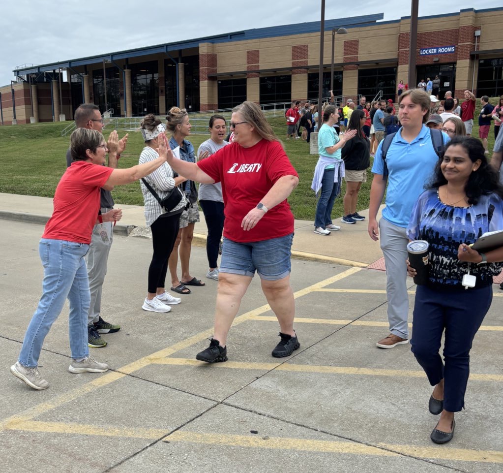 All the staff cheer for the new teachers during the traditional staff bridge walk in early August.