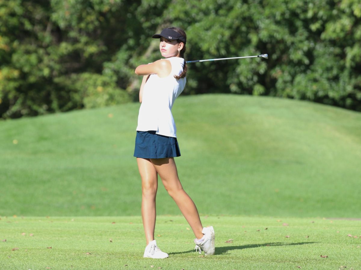 Jamie West (9) watches her ball as she finishes her swing.