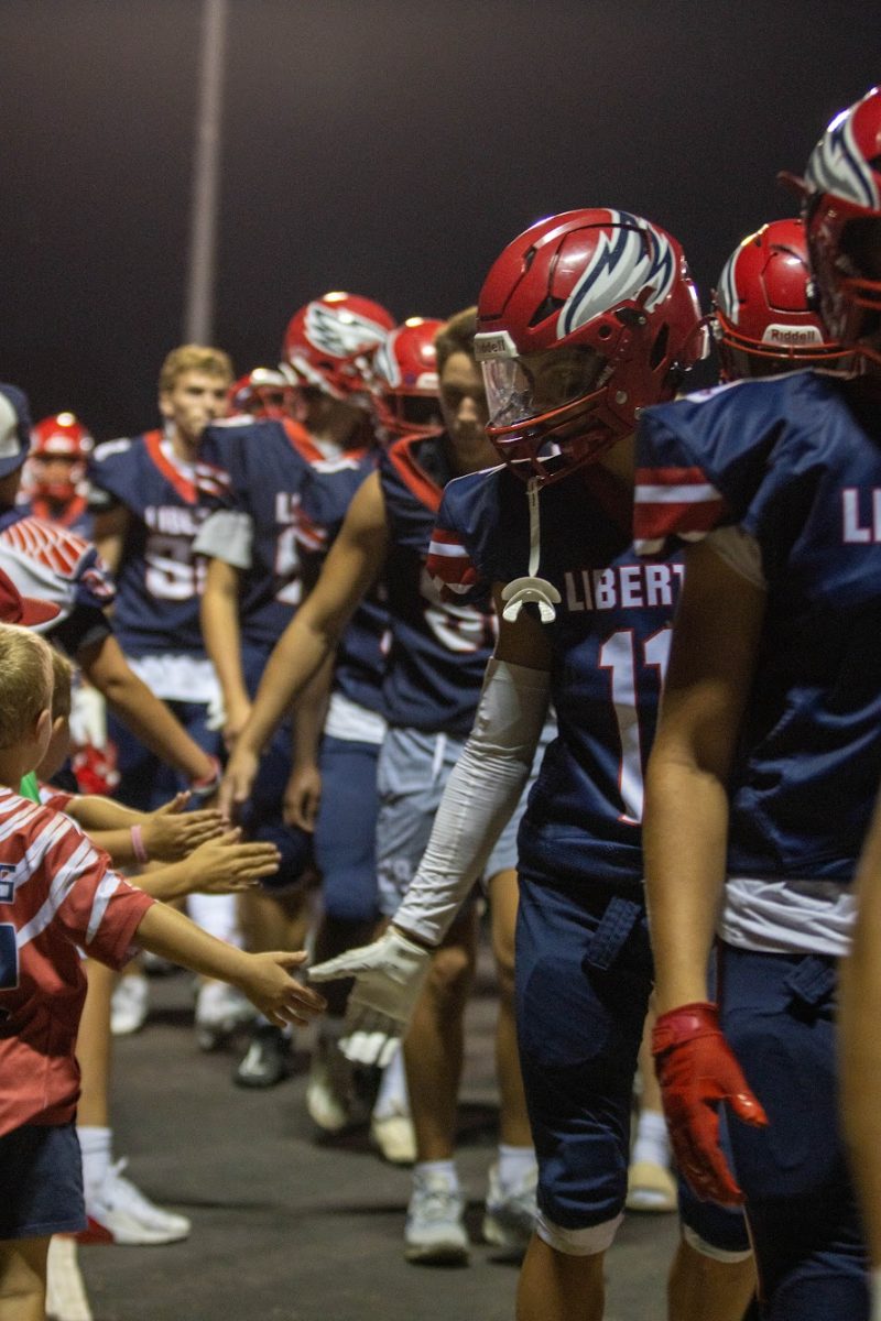 Eagle players high five excited members of the Jr. Eagles football team as the team walked out for halftime. 
