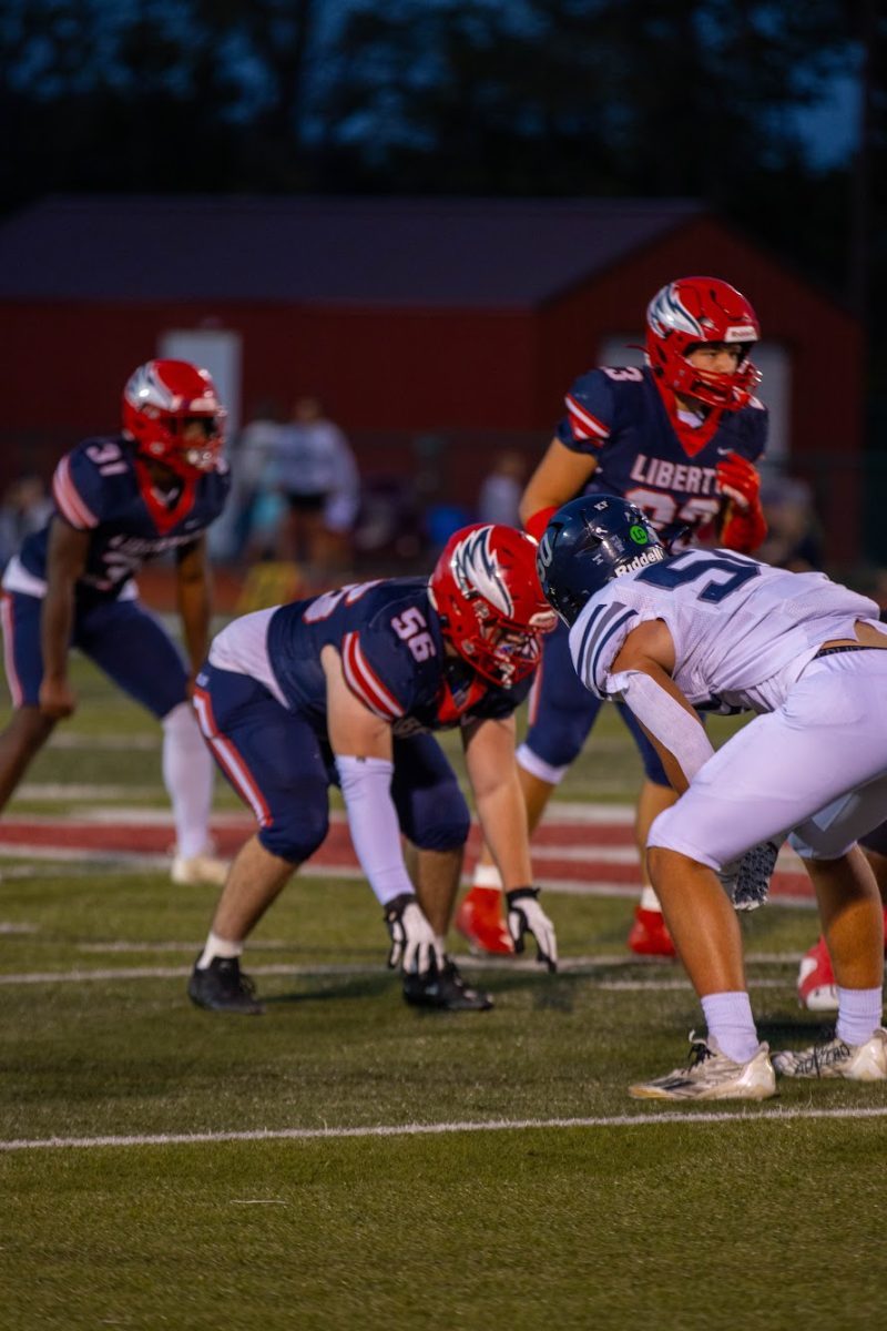 Alex Melton (12) crouches into position while Jack Ryan (12) and Jeremiah Safari (11) prepare for the play to start. 