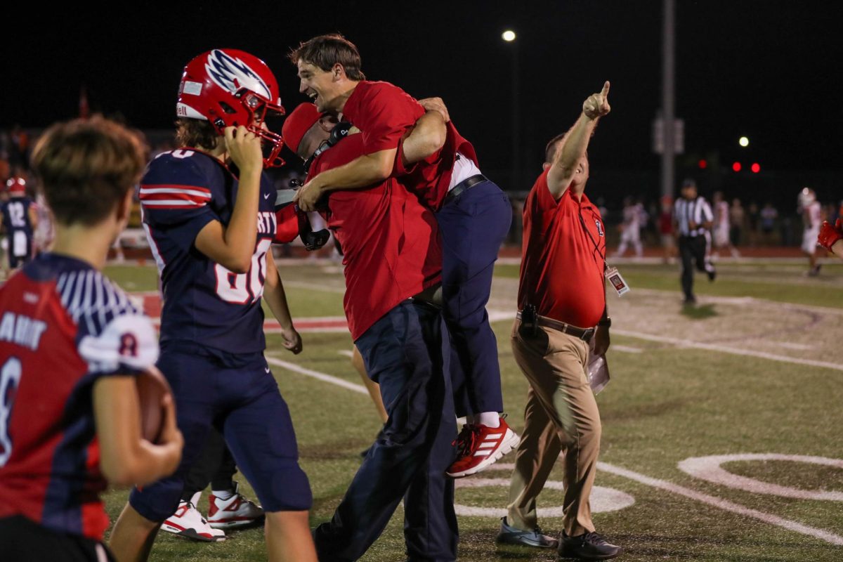 Coach Bradley Smith leaps with joy into the arms of Coach McMillen. 