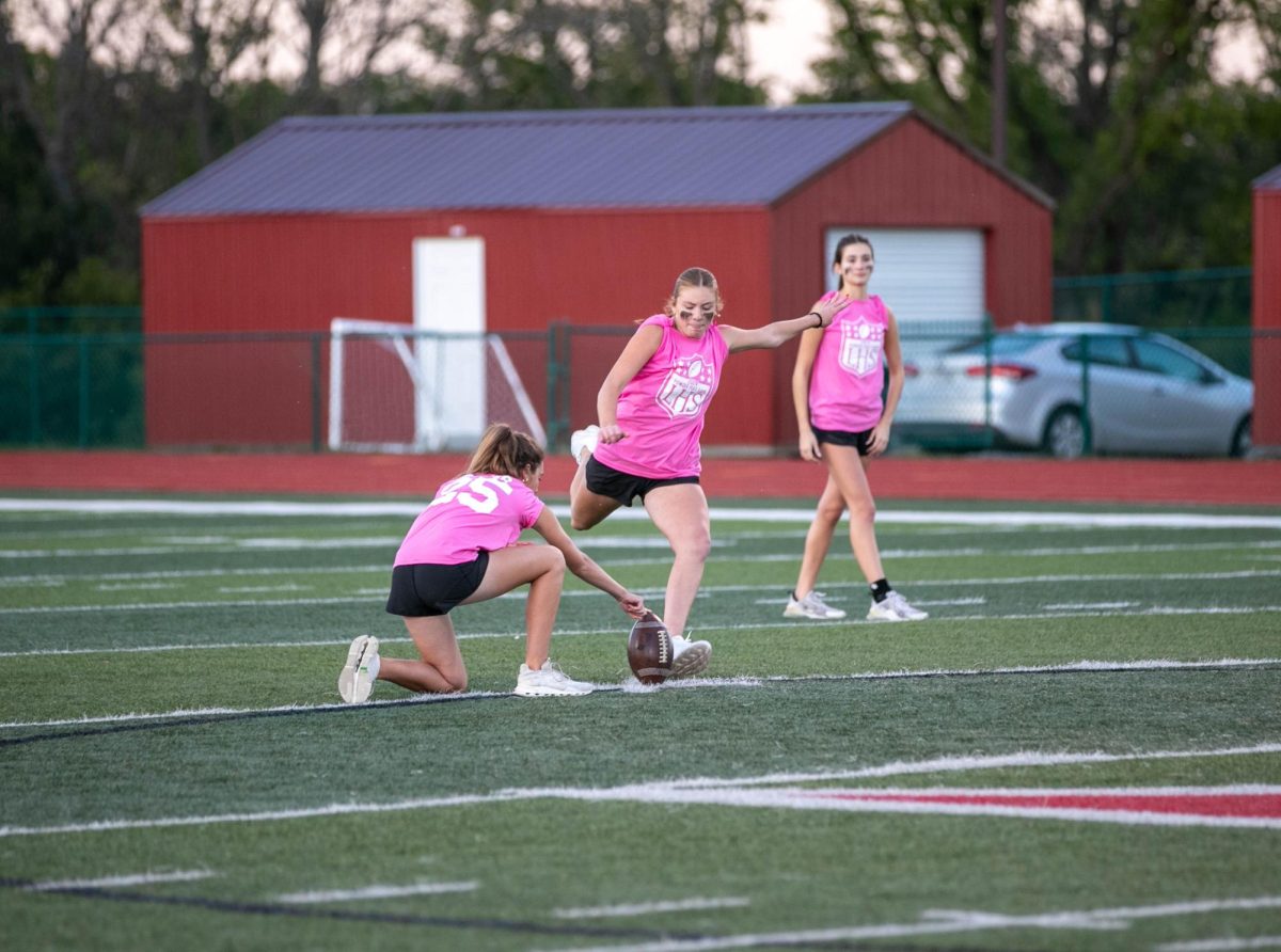 Sydney Eilermann (12) kicks the football for the kickoff during the first half of the annual powderpuff game on Oct. 2.