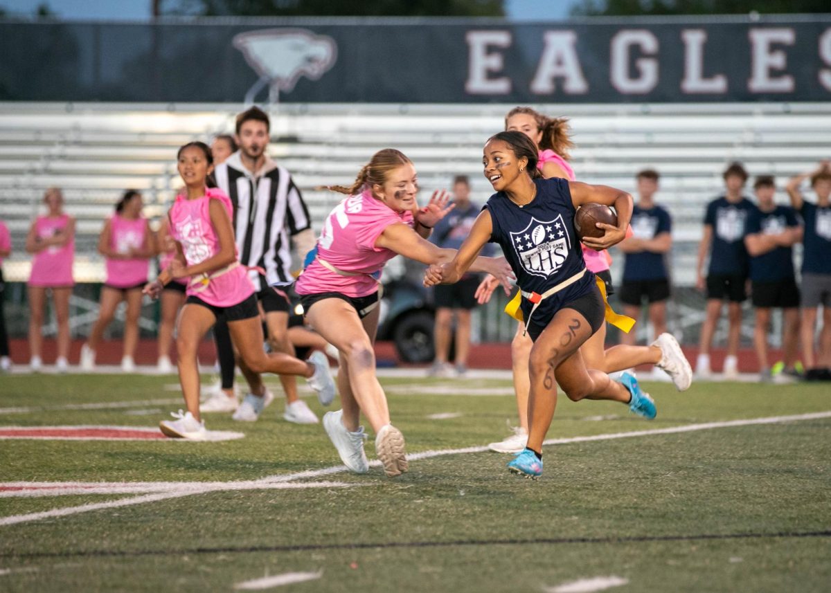 Arianna McCullough runs across the 40-yard line with the ball during the annual powderpuff game on Oct. 2.