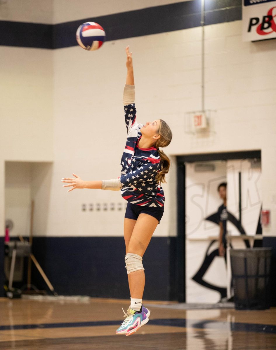 Lucy Siterlet (9) jumps up ready to serve the ball.