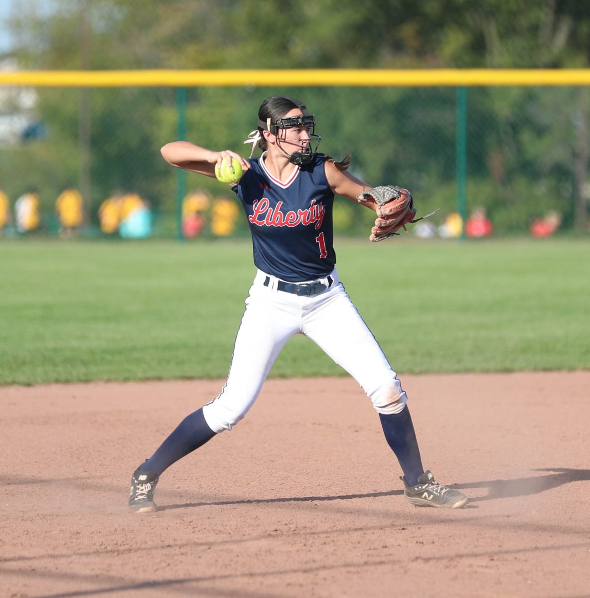 Payton Hemmer (12) gets ready to throw the ball to first base player Baylie Roetemeyer (12).