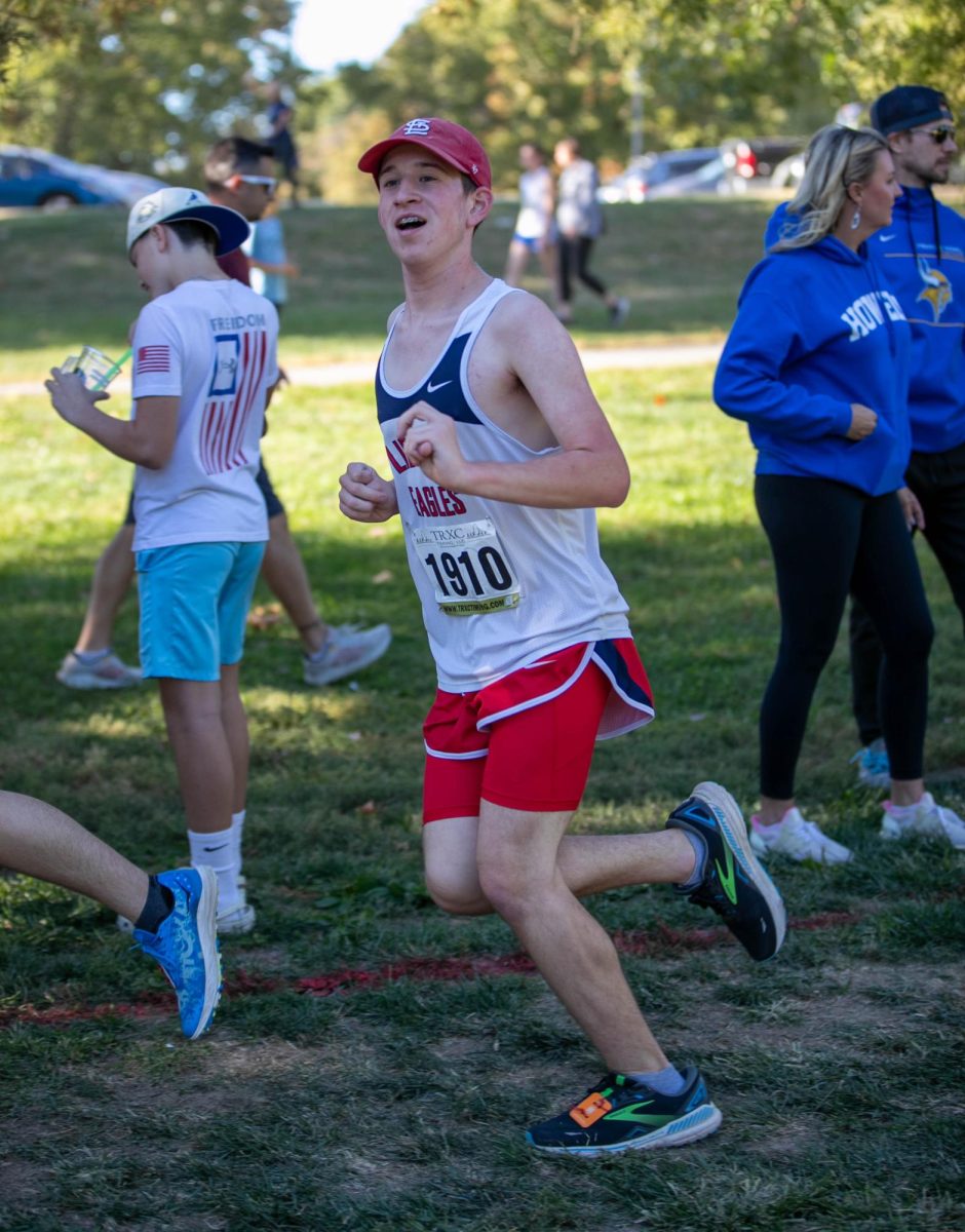 Cameron Daugherty (10) smiles toward guiding assistant while running during his GAC Conference race.