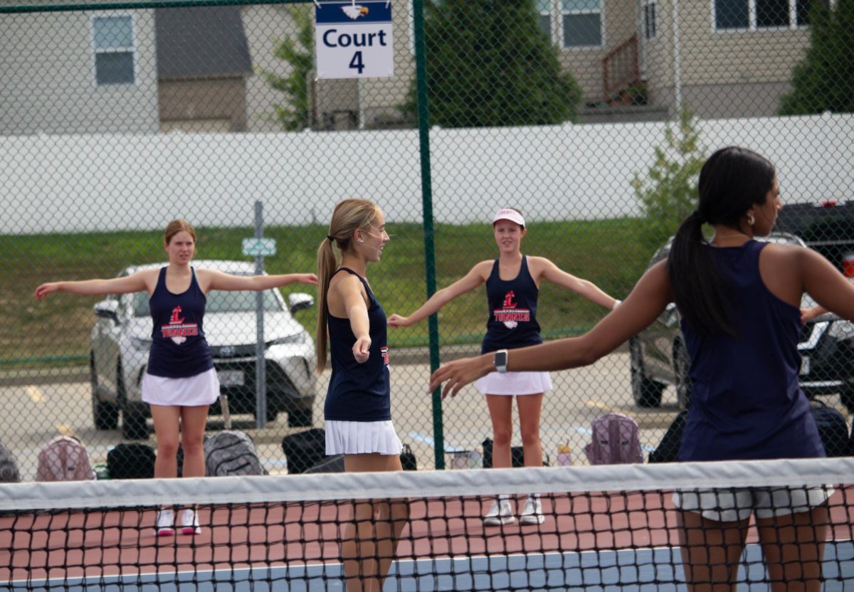 Izzy Shew (9) leads the JV tennis team in warm ups.