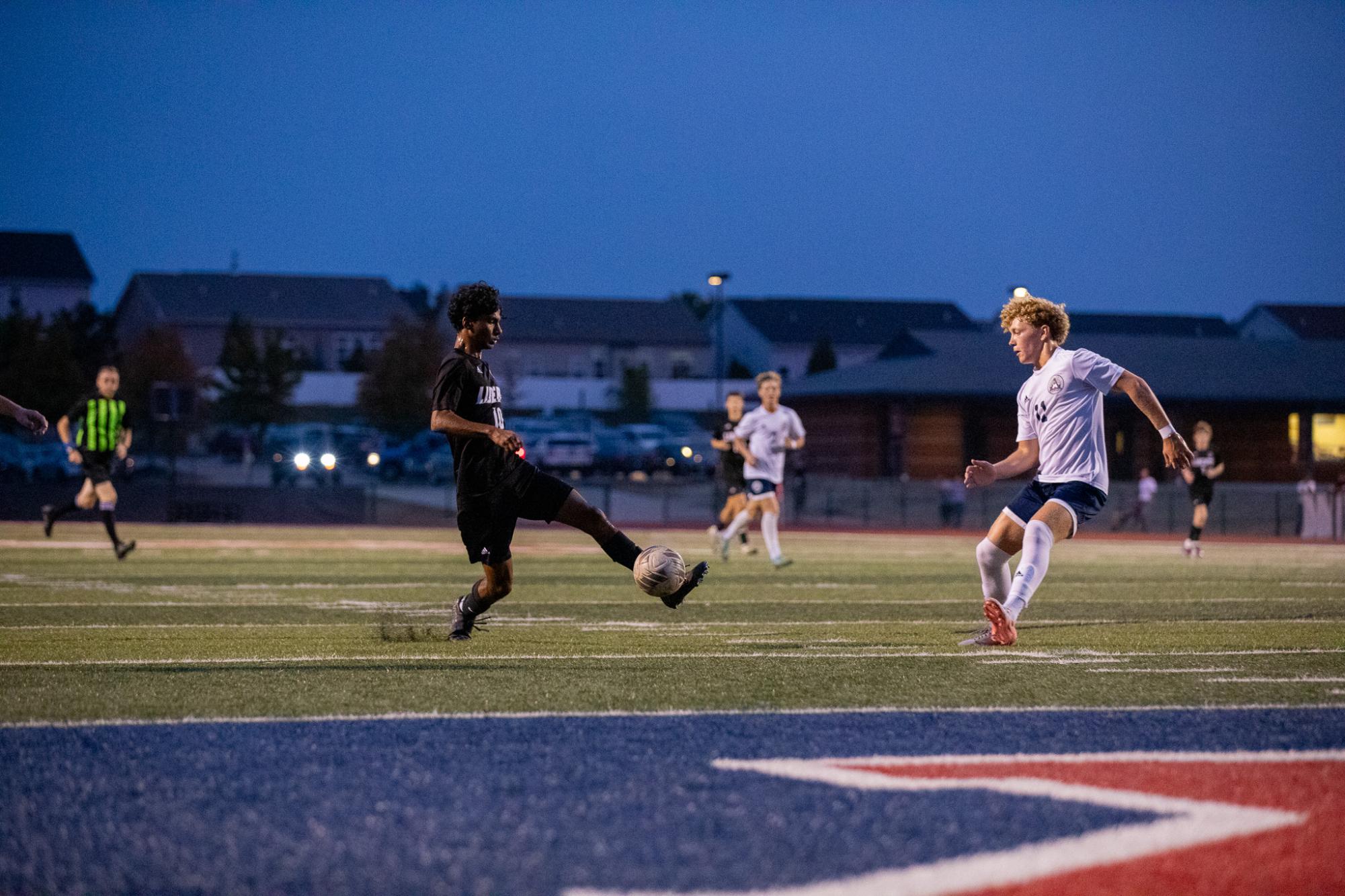 Ryan Sinclair (12) settles the ball in front of the defender, ready to shoot the ball. 