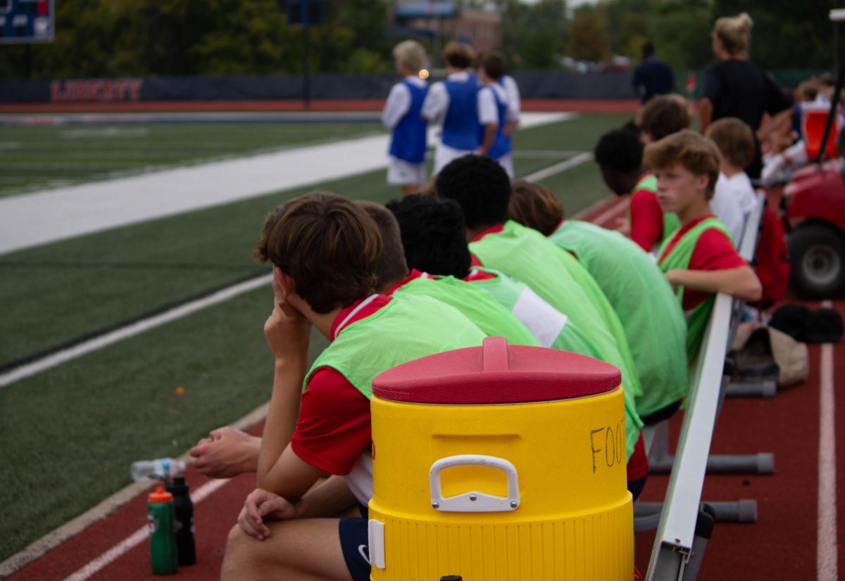 The JV boys soccer players watch their team from the bench in a match against Howell Central.