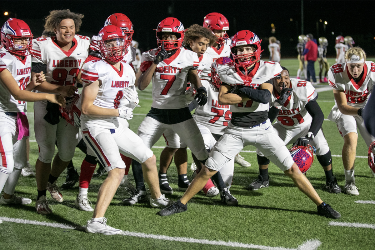 The Liberty football squad celebrates after the win over Holt.