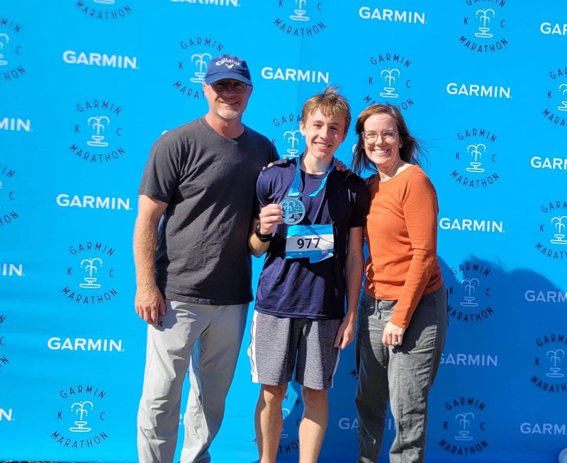 After his marathon, Bradley Hudson (12) stands next to his parents with his medal.