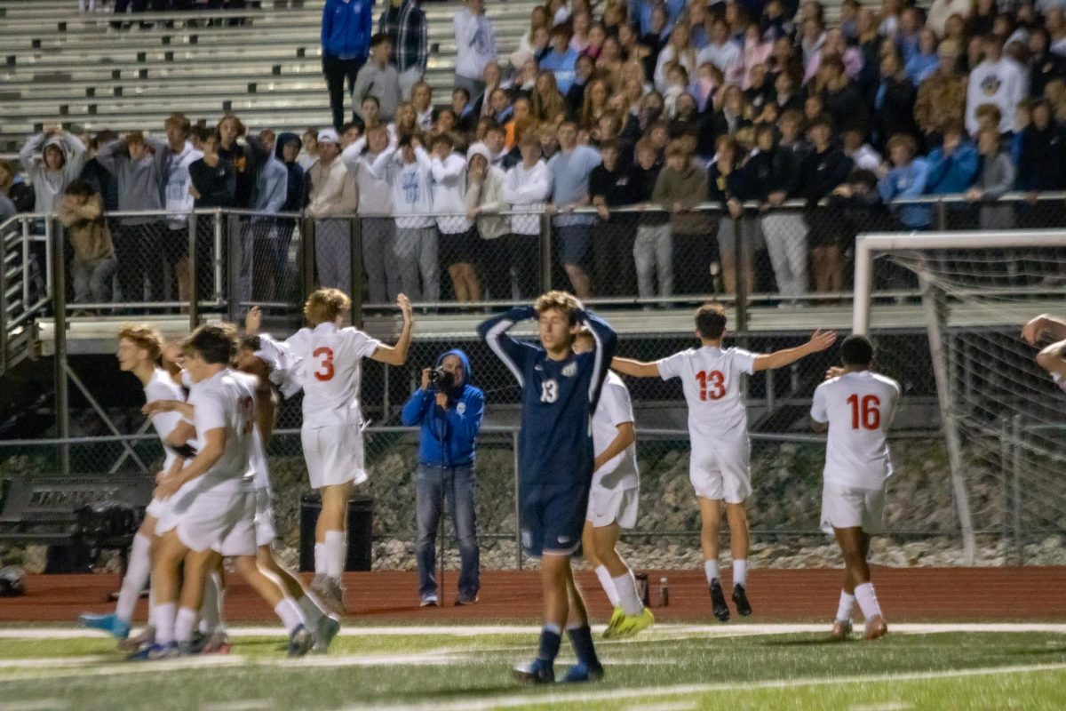 The boys varsity soccer team celebrates their district championship win in front of the St. Dominic student section.