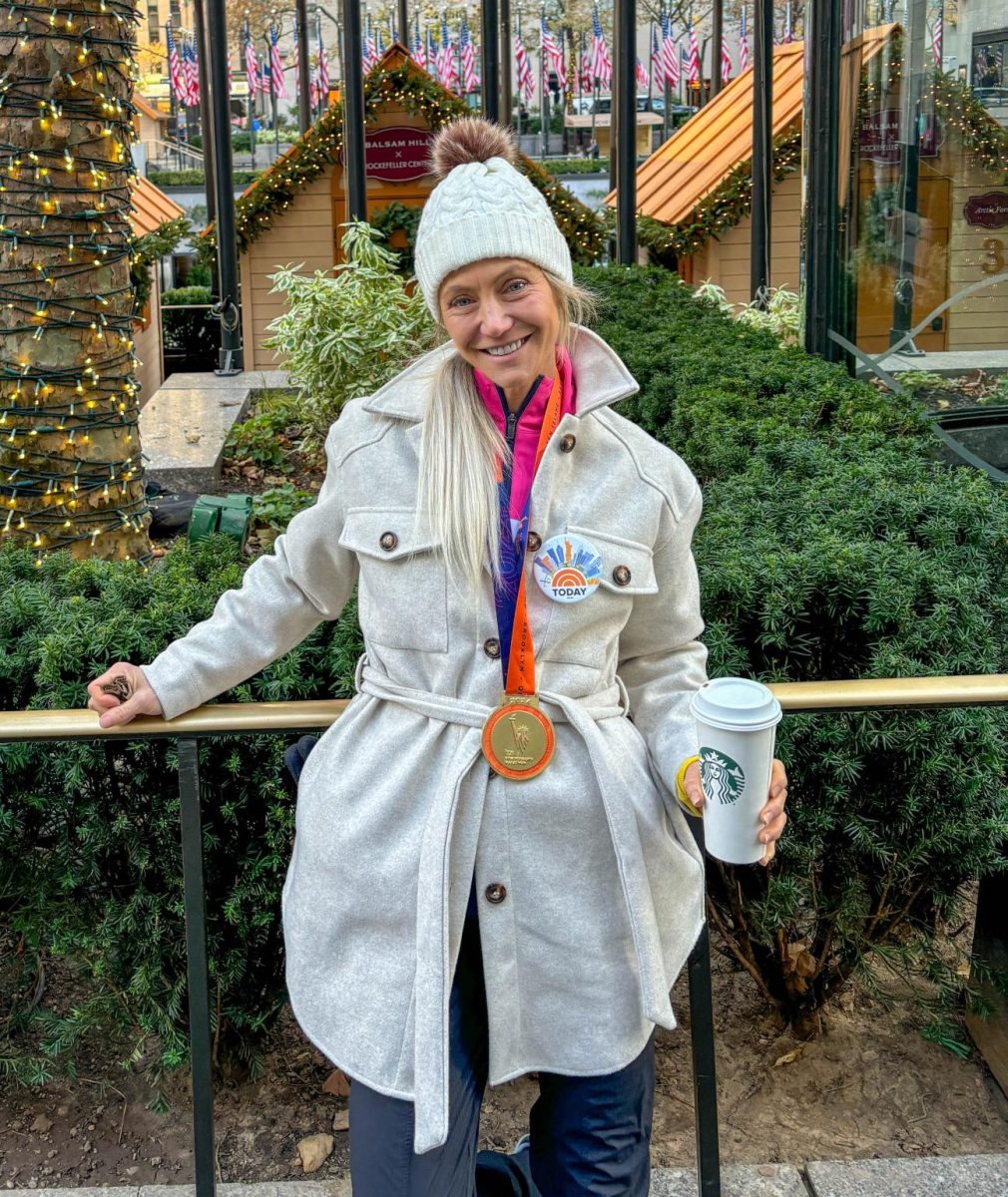 Standing outside of Rockefeller Center, Jackie Hall wears her medal the next day after she ran the New York Marathon.