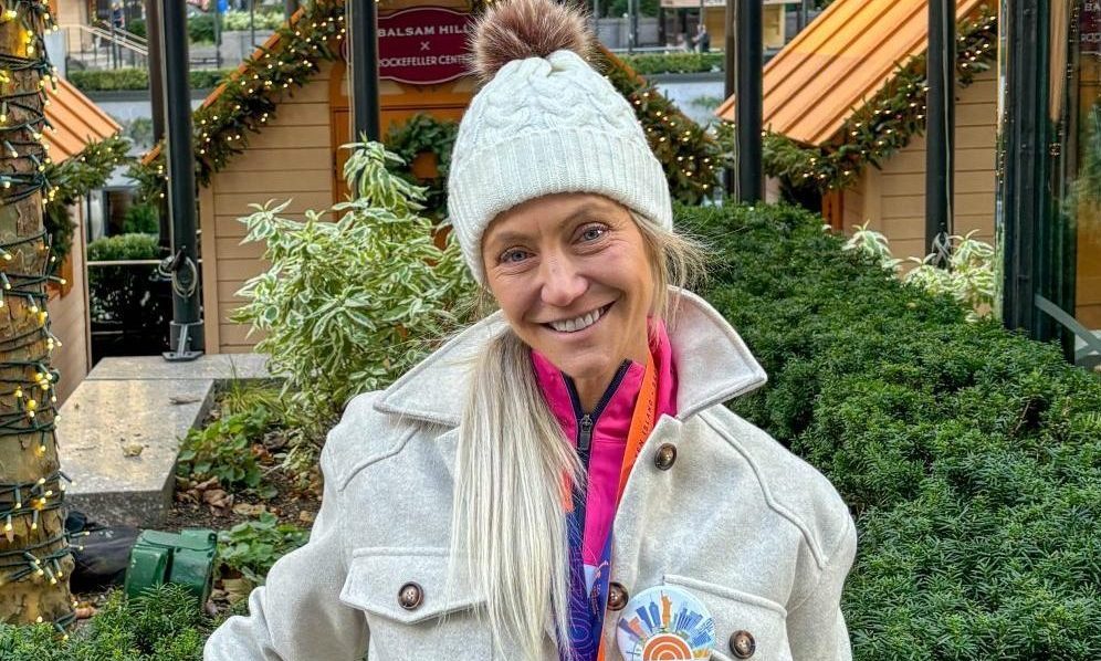 Standing outside of Rockefeller Center, Jackie Hall wears her medal the next day after she ran the New York Marathon.