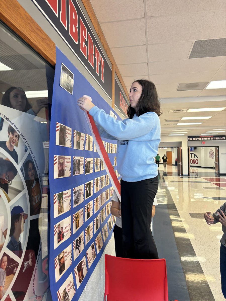 NHS member Anna Fleetwood (12) works on the Remembrance Banner in honor of Veterans Day.