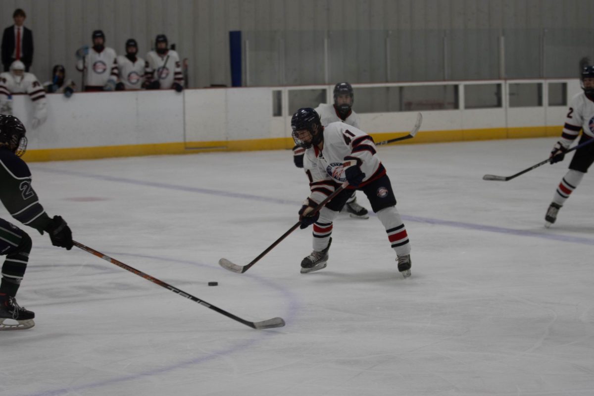 Nicholas Kuhn (10) receives the puck from  teammate and proceeds to move the puck to the other teams zone. 