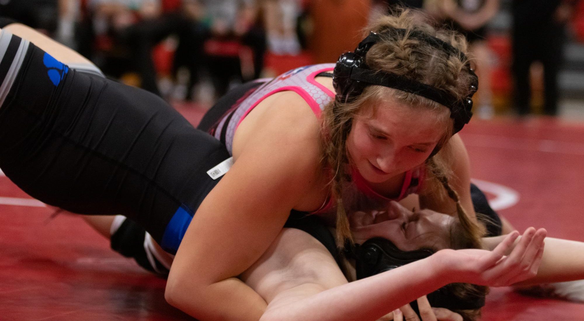 Lexi Daniels (10) looks down at her opponent while attempting to pin her.