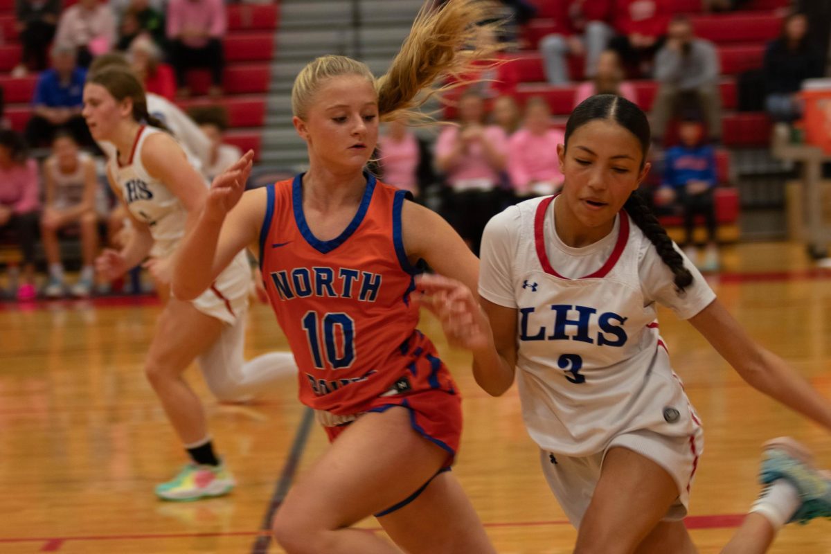 Sanaa Woods (11) dribbles ball while North Point defender blocks her.