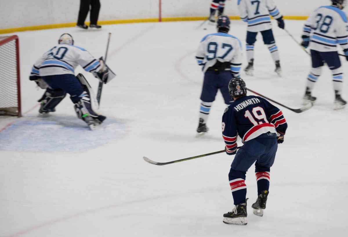 Greyson Howarth (11) looks over at teammate who has the puck in St. Dominic's defensive zone.