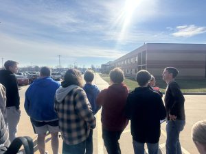 Students and staff members stand outside in below 40 degree weather waiting safely away from the school.