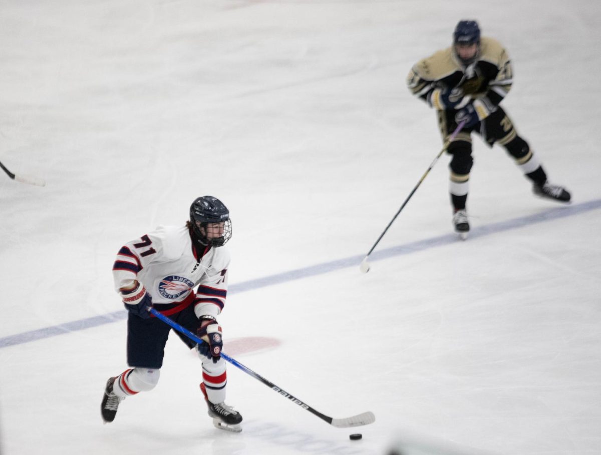 Connor Casella (10) carries the puck to East's defensive zone.