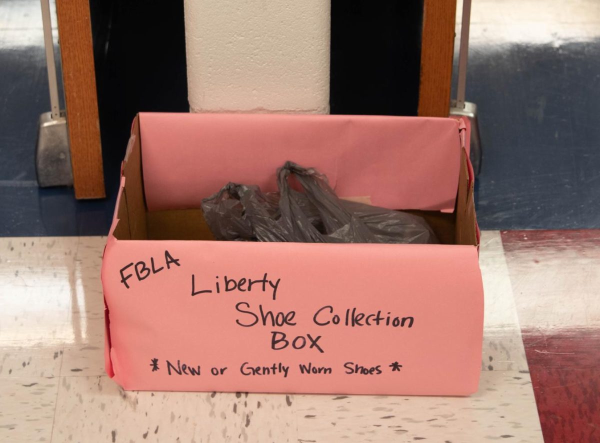 Shoe Drive box in the beginning of the 300 hall way with a pair of shoes in it. 