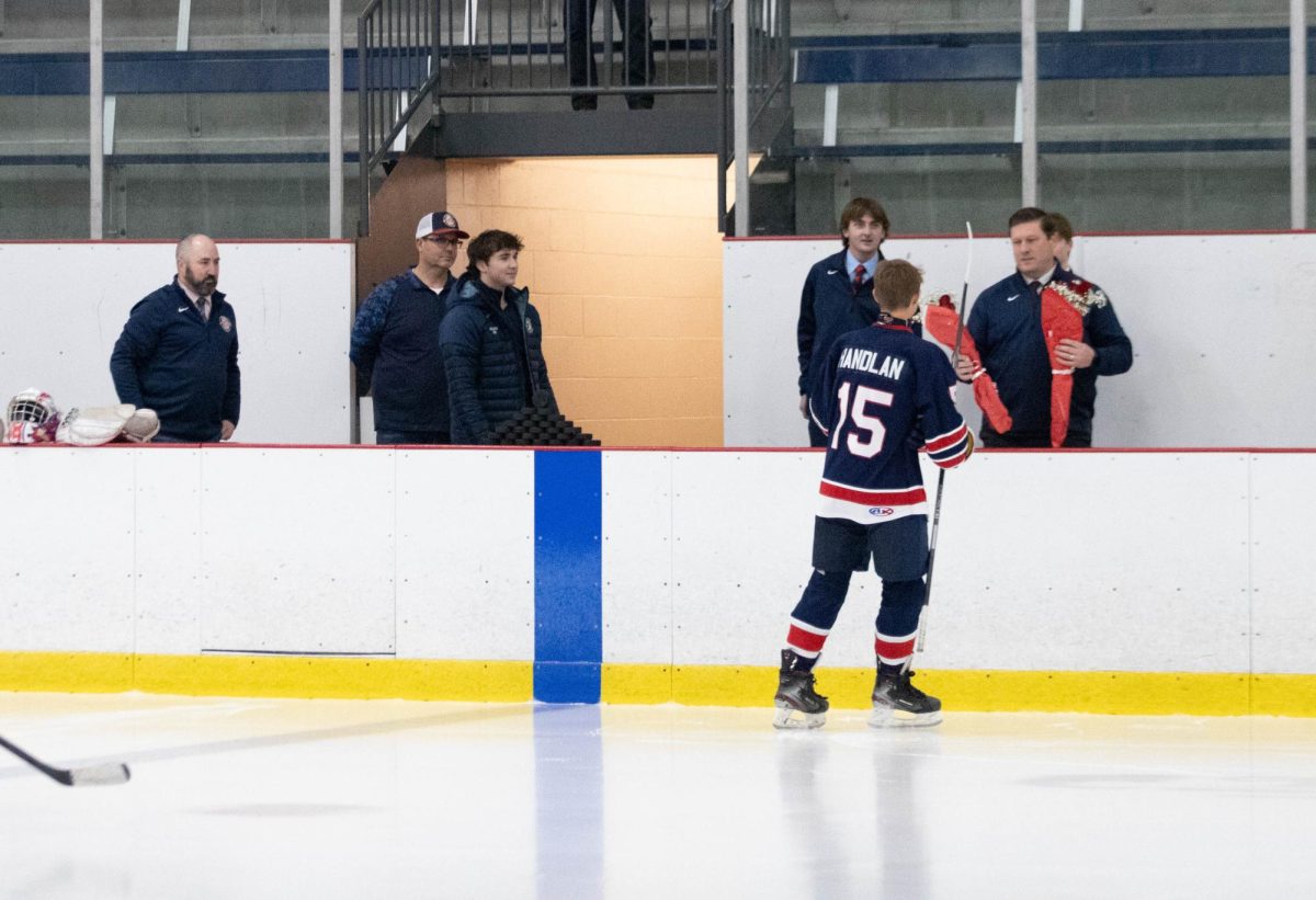 Dylan Handlan receives flowers from head coach to give to his mom.