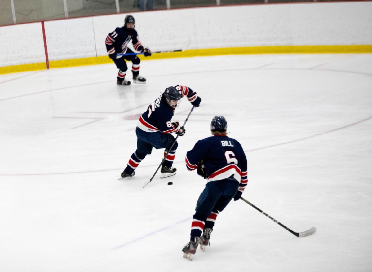Owen Francis (9) stick handles puck while Jude Bill (11) skates with him.