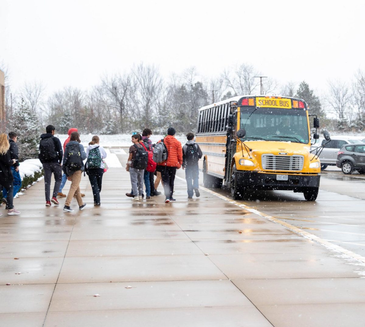 Students leave school during a winter flurry despite less than favorable conditions .