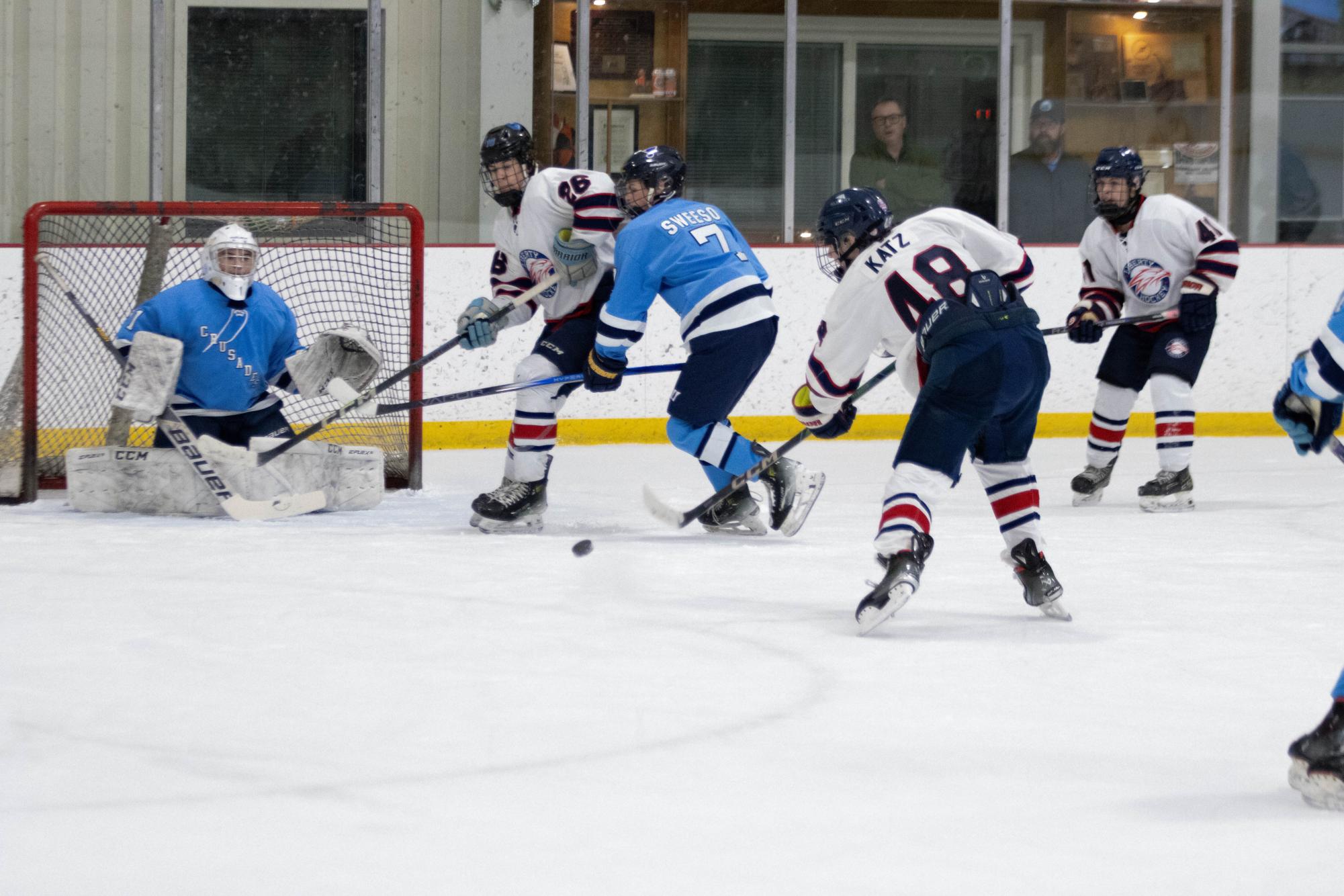 Garrett Katz (10) shoots the puck while Zach Pruss (11) gets ready for the rebound.