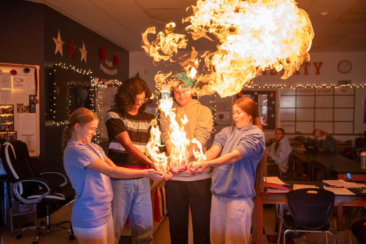 Reece Hoffman (11) and three other students get their hands set on fire in a chemistry.