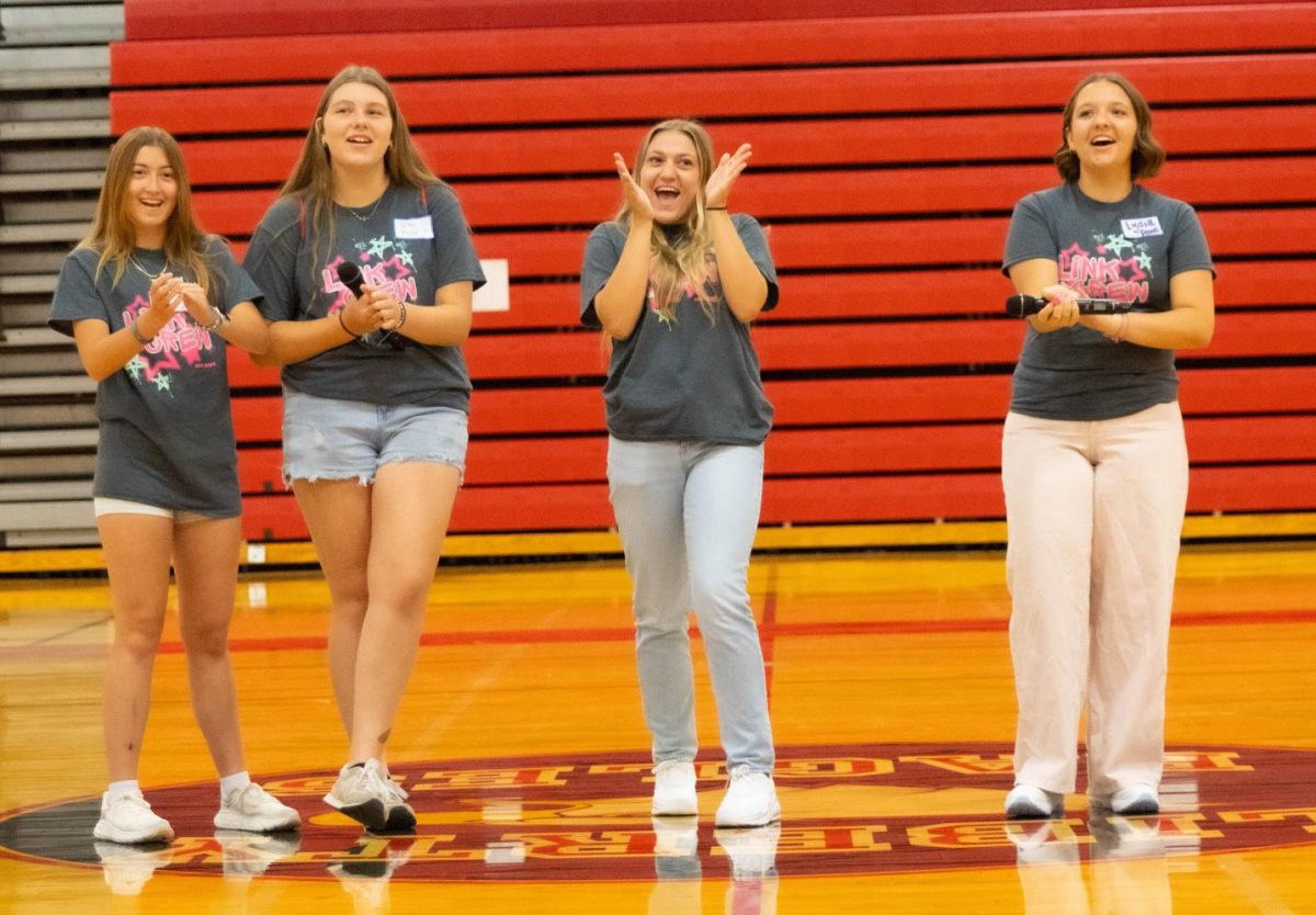 Ellie Simon (11), Ellie Force (11), Izabella Signaigo (12), and Lydia Davis (11) clap as they welcome the Class of 2029 to orientation.