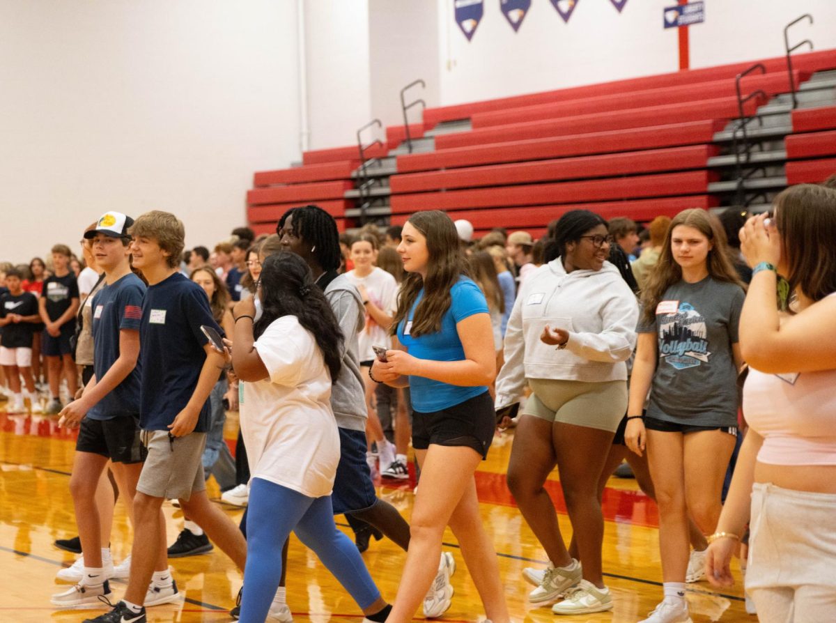 Students walk to the other side of the gym during a game of Agree or Disagree.