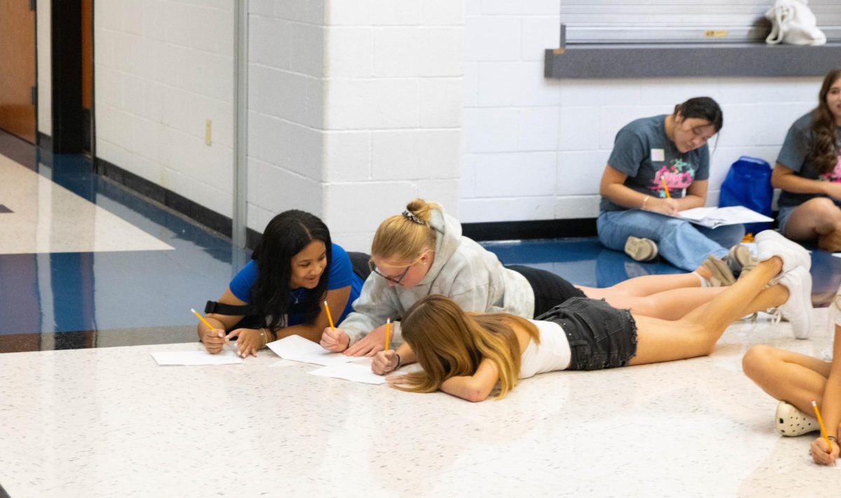 Students work together during a game of get to know you with drawings.