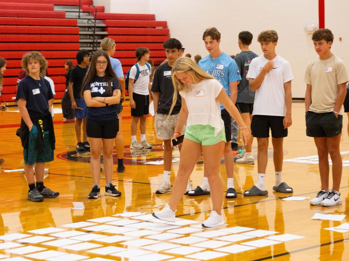 Vayda Terrelle (9) walks across the "bridge" trying not to step on any "turtles" in a group activity.