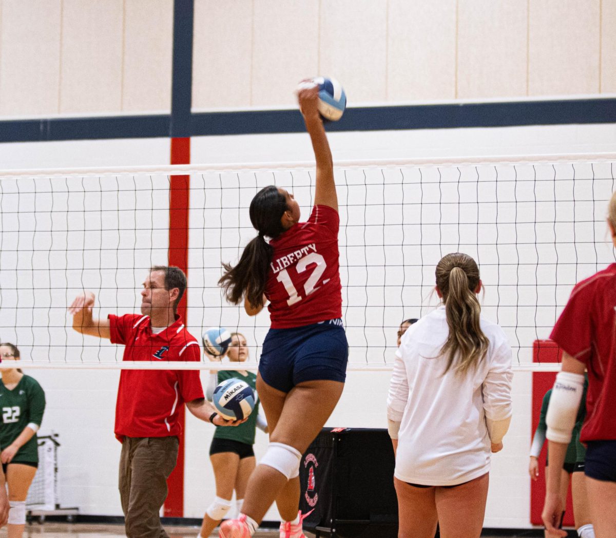 Pellegrino spikes the volleyball over the net during pre-game warmups. 
