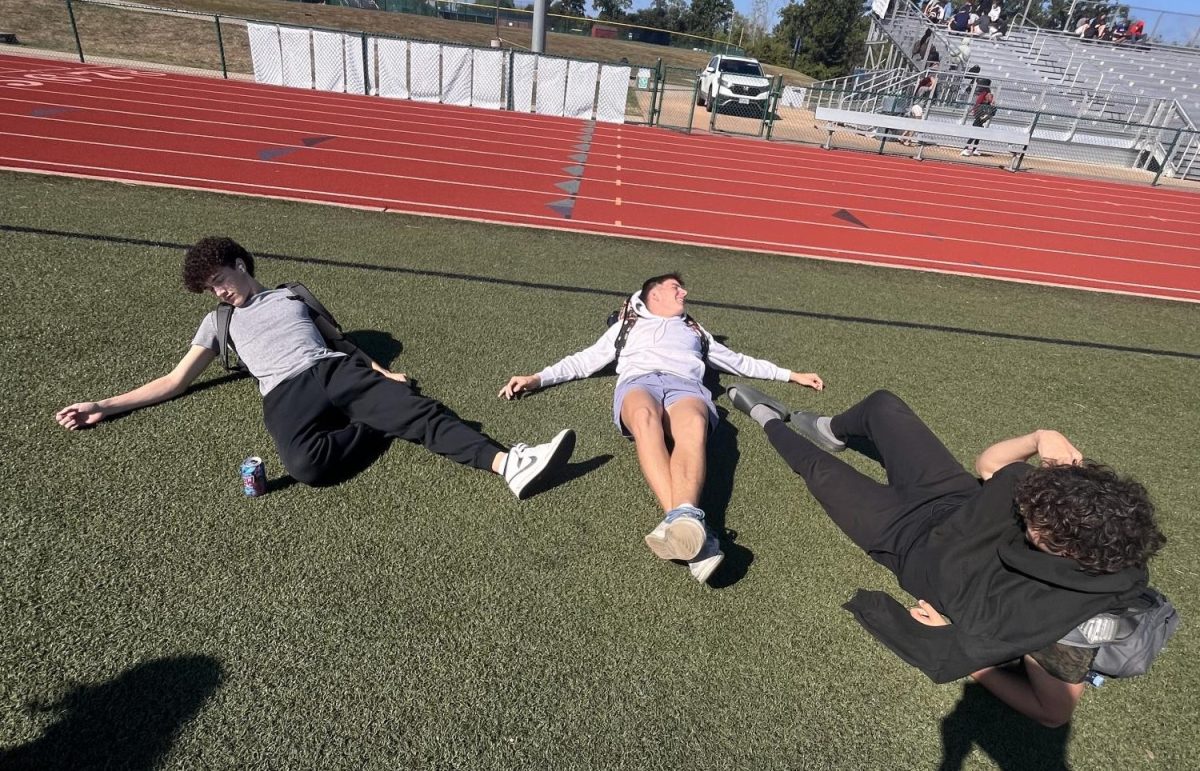 Jackson Adams(11) Kaden Brower (11) Rei Krushova(11) hanging out on the field  during lunch