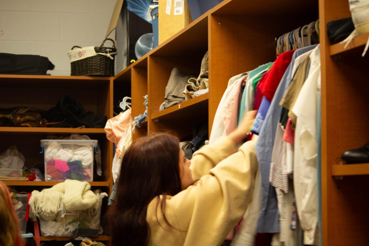 Costume crew member Sage Kennedy (11) looks for an outfit to put together.