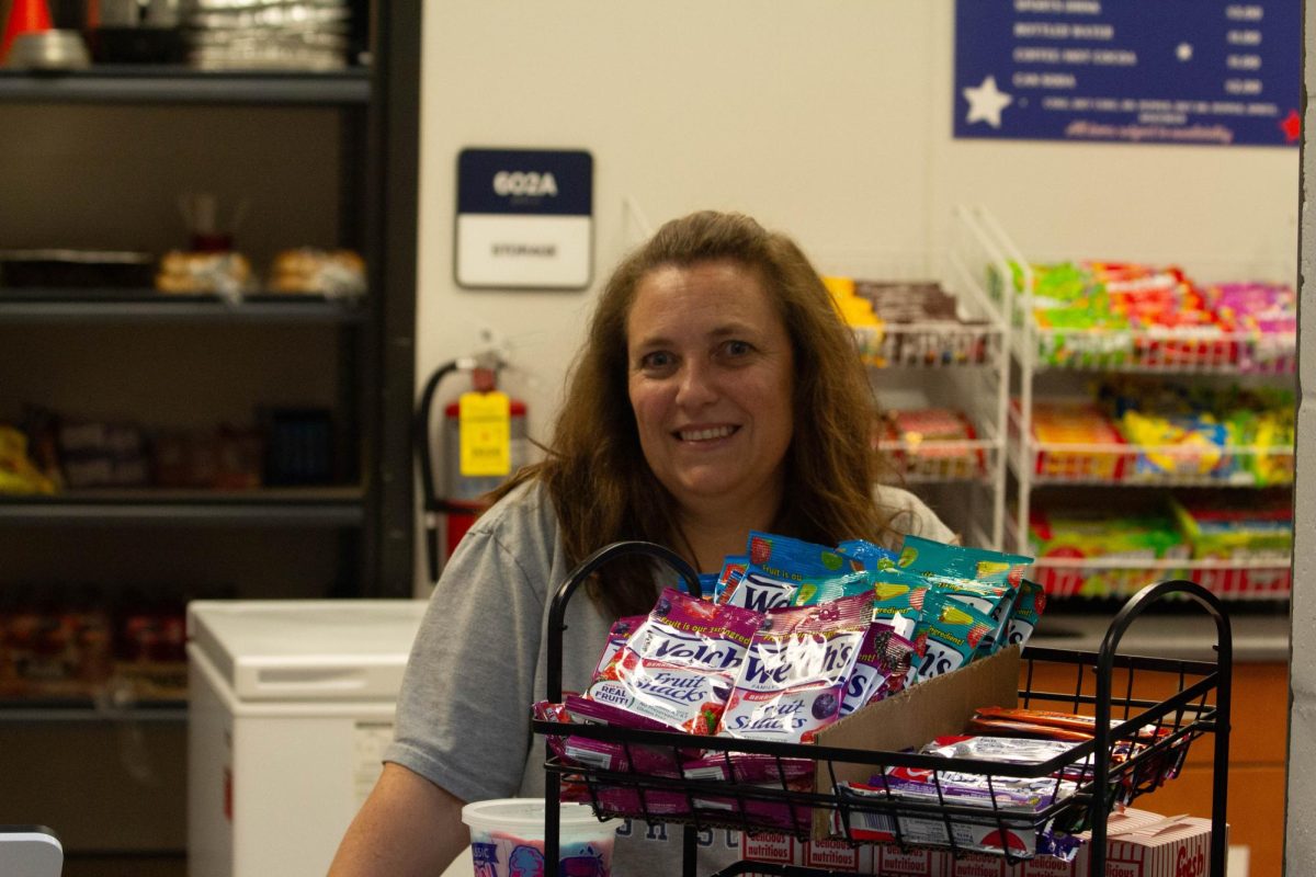 Booster Club board member Shannon Queen serves concessions for a volleyball game. 