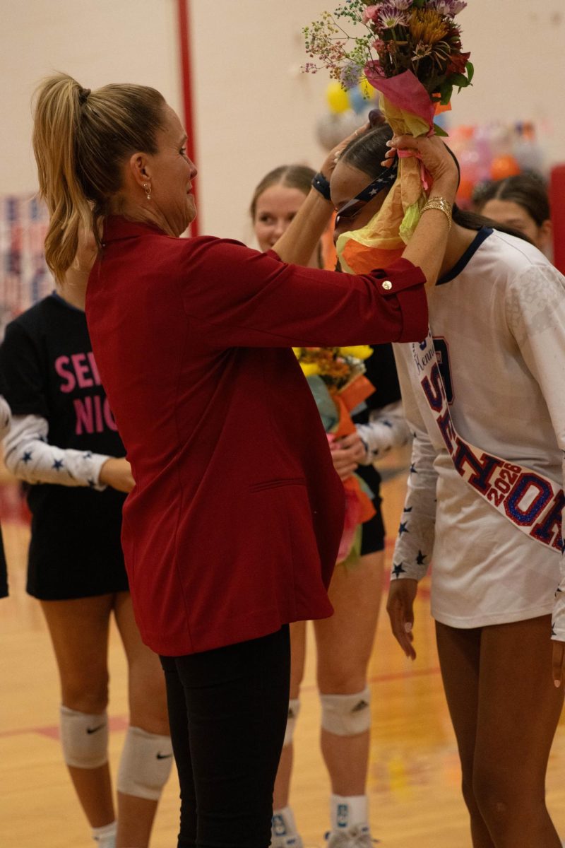 Kenna Harris (12) receiving a medal from head coach Veronica Kirkpatrick.